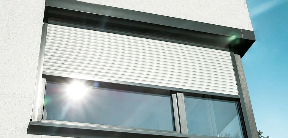 Außenrollladen am Fenster einer Hausfassade, moderner Sonnenschutz außen