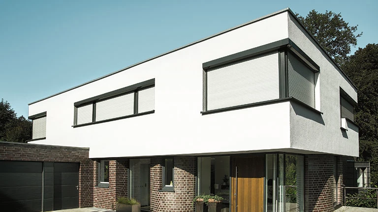 Modernes Einfamilienhaus mit Flachdach, großen Fenstern und Garage außen