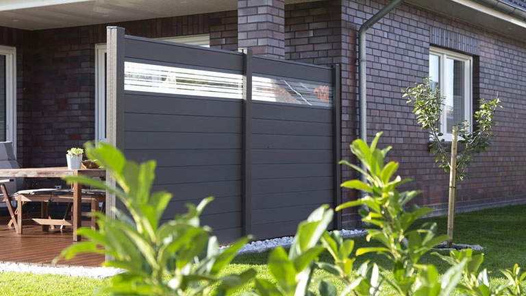 Moderner Sichtschutzzaun aus WPC am Garten vor Haus mit Terrasse